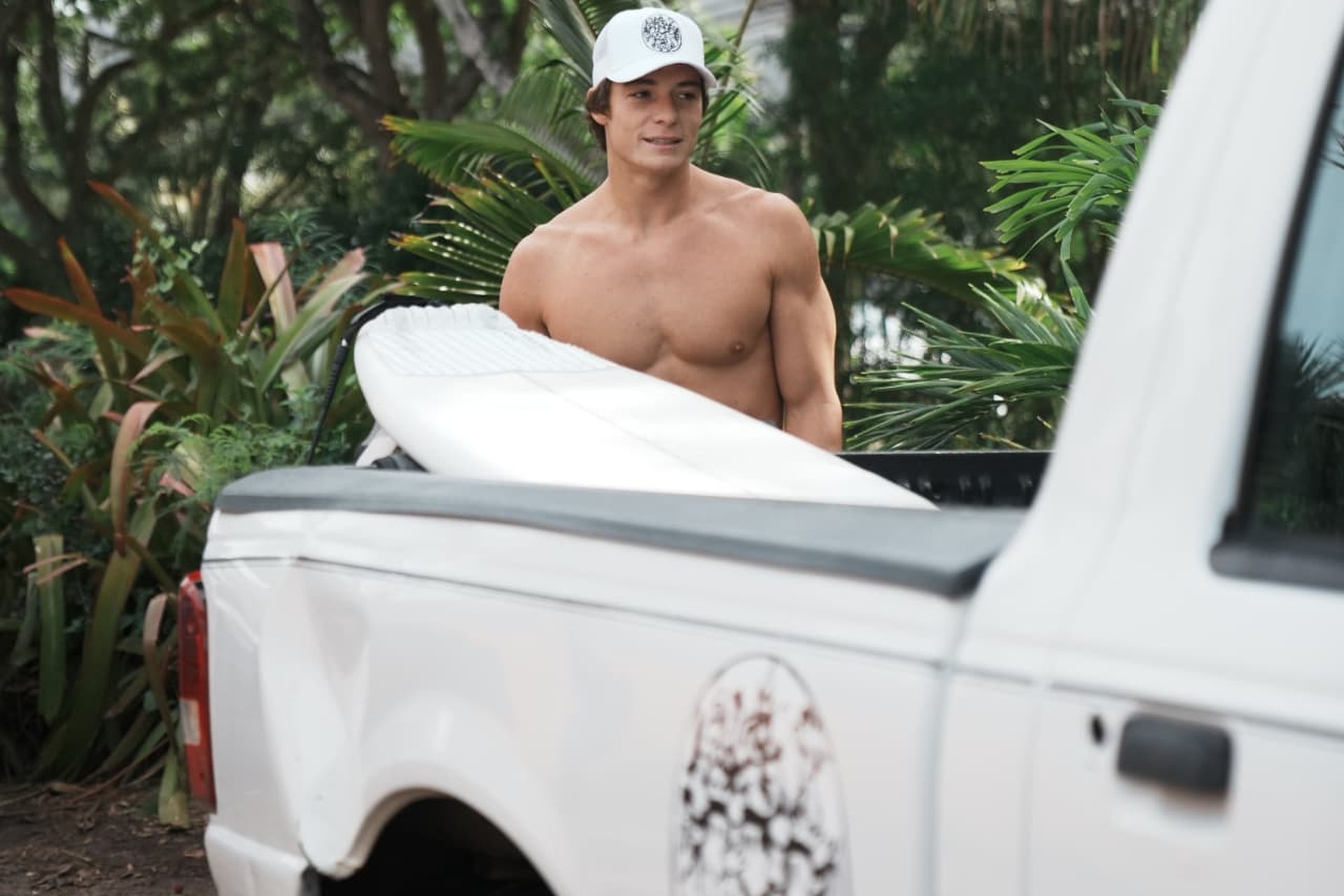 Ragazzo con tavola da surf accanto al pick-up
